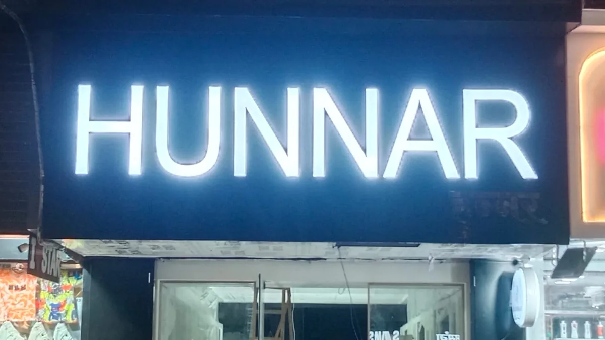 Back-lit acrylic shop lettering glowing at night