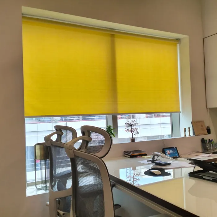 Yellow roller blind over a workstation window