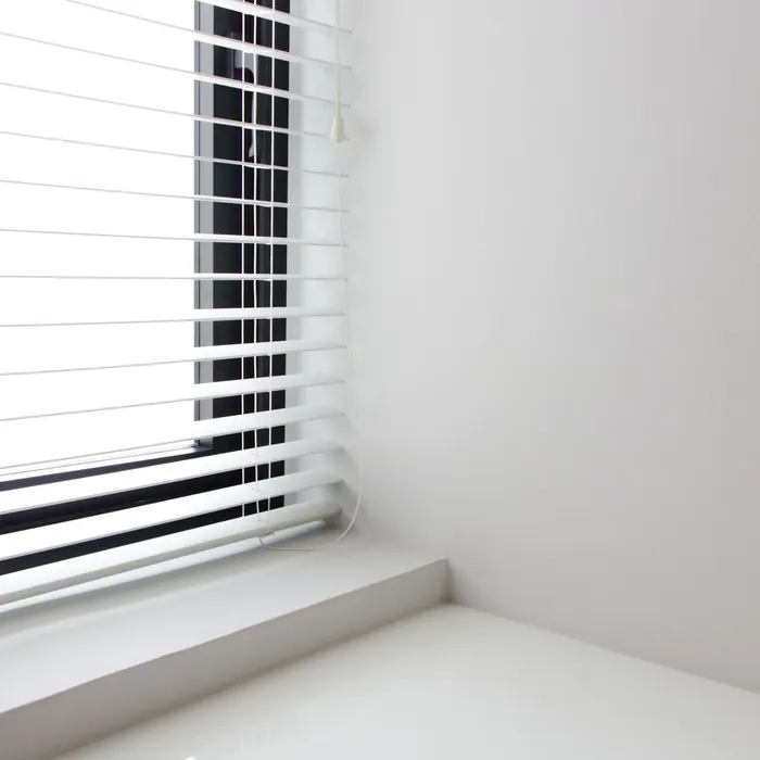 Venetian blind above a deep white window sill
