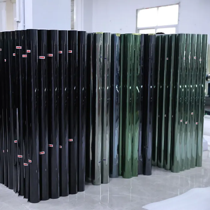 Rolls of tinted window film stacked in the workshop