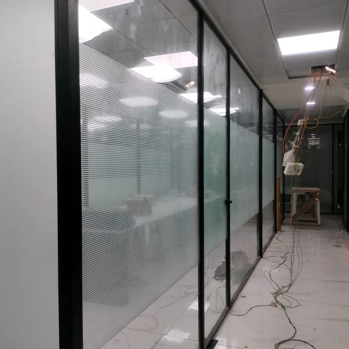 Office corridor lined with frosted glass cabin partitions