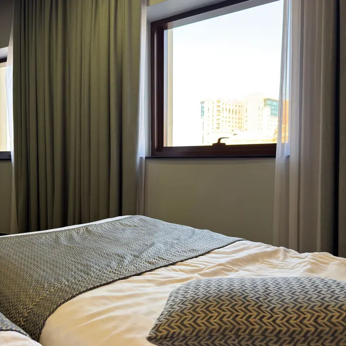 Guest room window dressed with full-length curtains