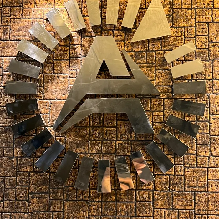 Mirror-finish metal lettering mounted on a textured wall