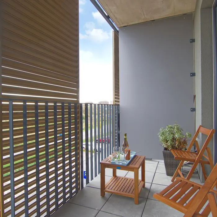Outdoor slatted blind shading a balcony seating area