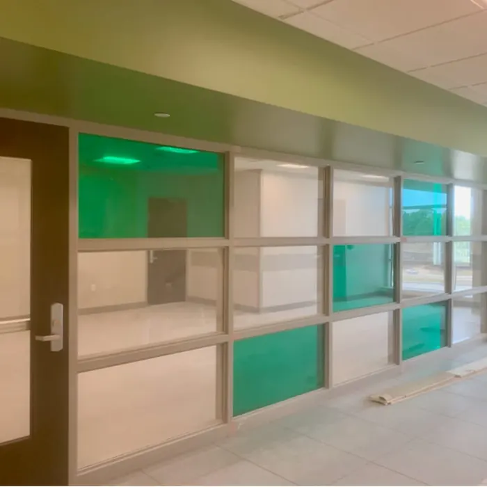 Green and white film panels in a school passage