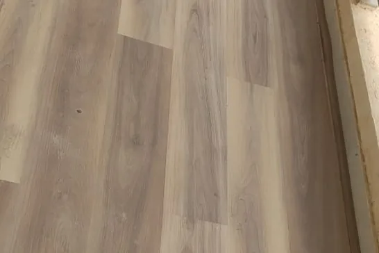 Oak-effect plank flooring running unbroken across a room