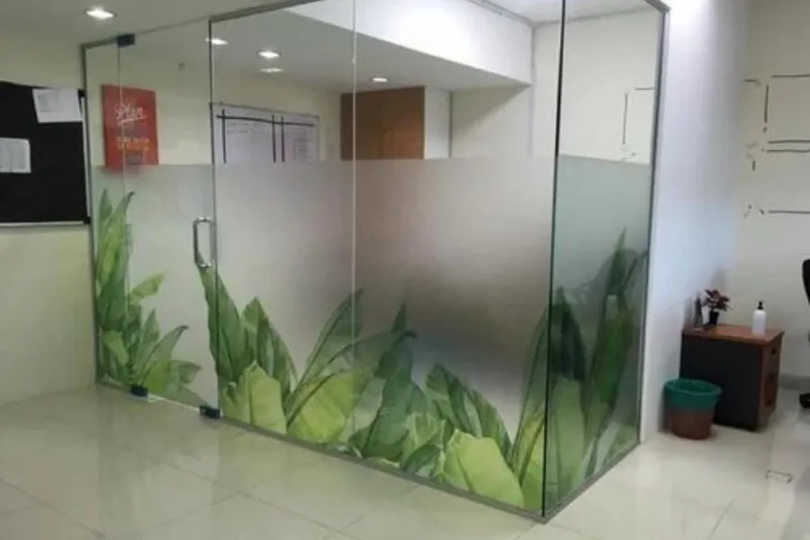 Printed green leaf gradient along a glass office partition