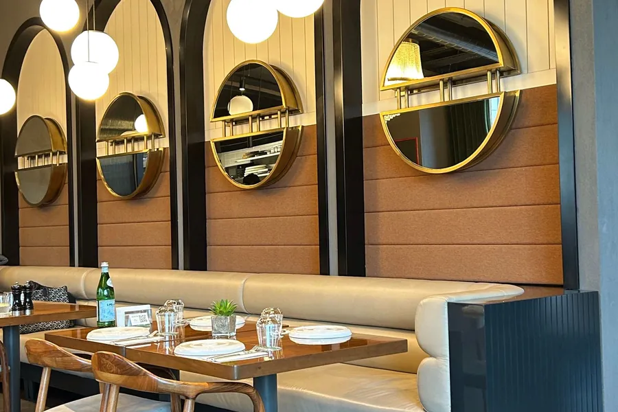 Arched mirror panels lining a restaurant's seating wall