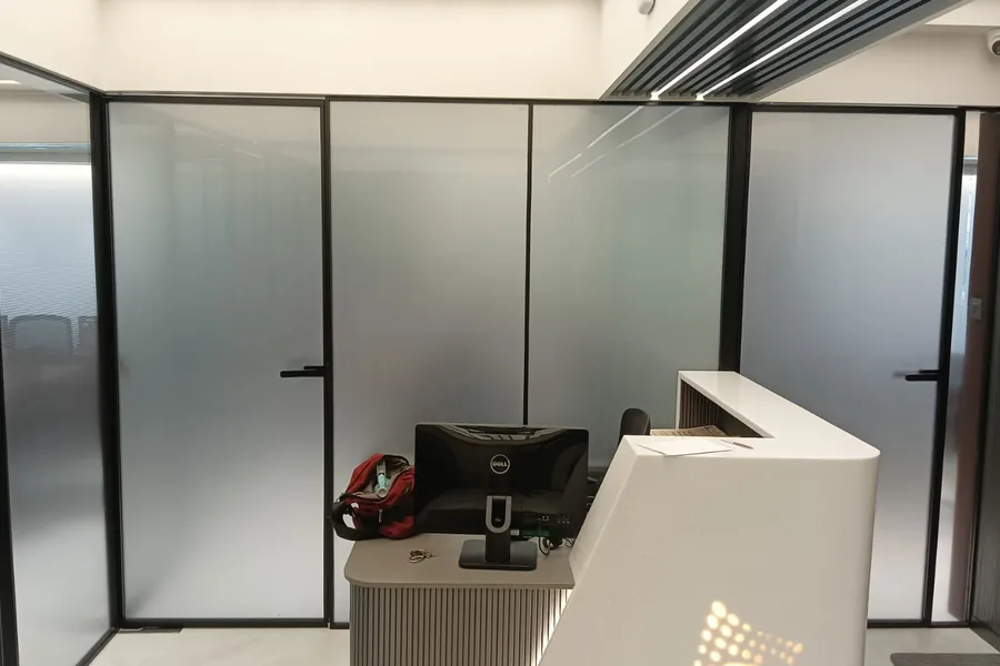 Reception fronted by black-framed glass partitions