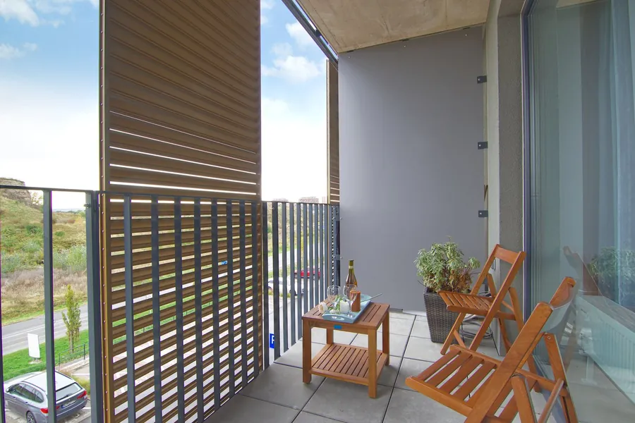 Outdoor slatted blind shading a balcony seating area