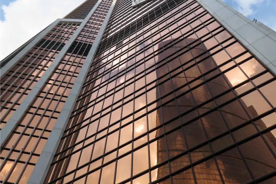 Sunlight raking across a reflective high-rise glass facade