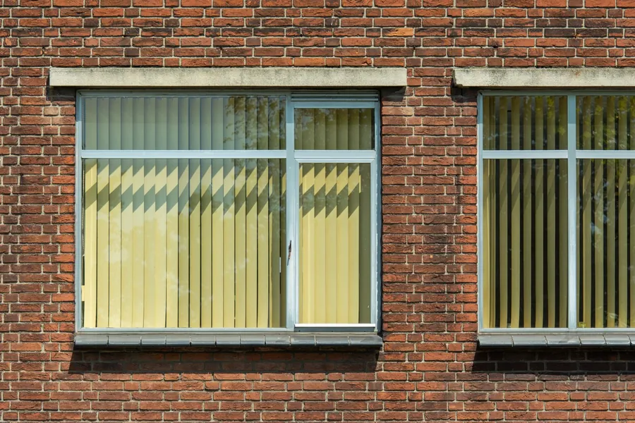 Vertical blinds hanging in a row of office windows