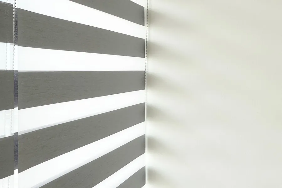 Alternating sheer and solid bands of a grey zebra blind