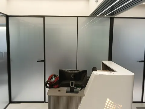Reception fronted by black-framed glass partitions