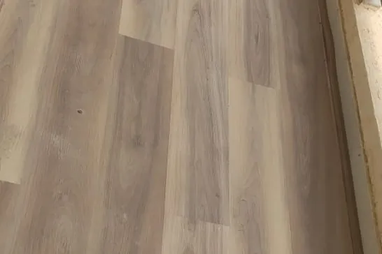 Oak-effect plank flooring running unbroken across a room